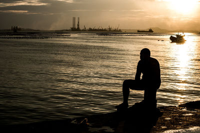 Silhouette of people in sea at sunset