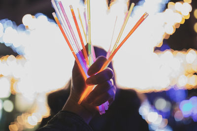 Close-up of hand holding multi colored lights