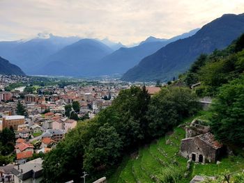 Aerial view of townscape and mountains against sky