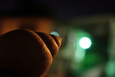 Close-up of hand holding illuminated blurred background