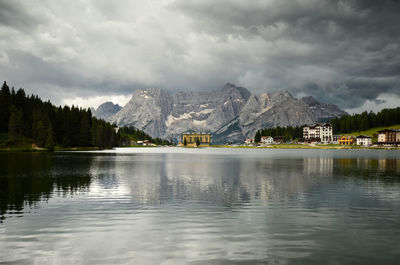 Scenic view of lake and mountains against cloudy sky