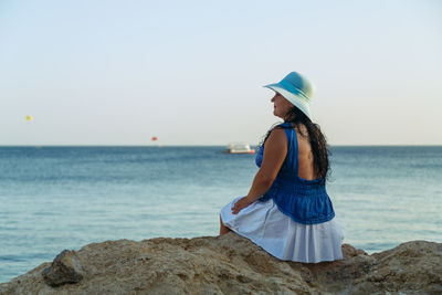 Woman in sea against sky