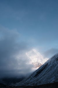 Low angle view of snow mountain against foggy sky in nepal abc trekking