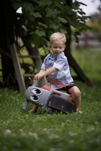 Portrait of boy playing with toy on field