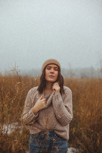 Portrait of woman standing on snow covered land