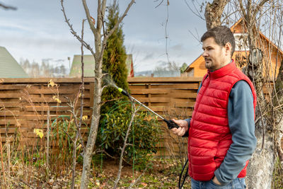 Spraying fruit trees with a pump sprayer with insecticides and fungicides in the spring season