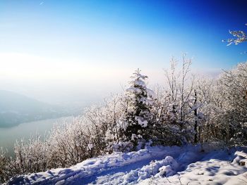 Snow covered field against clear blue sky