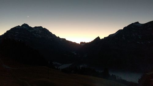 Scenic view of mountains against sky at sunset