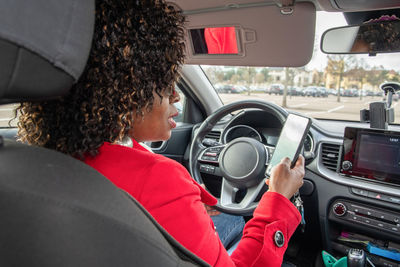 Satisfied young african american woman video chatting in car with someone