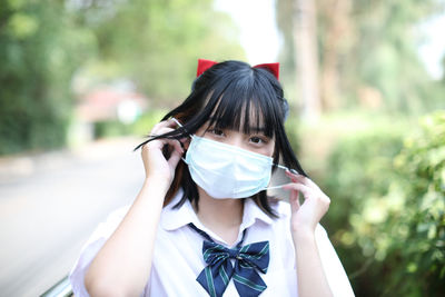 Portrait of beautiful young woman wearing mask outdoors