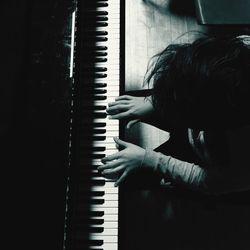 High angle view of person playing piano at home