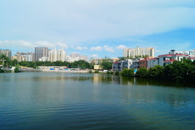 Buildings by sea against sky