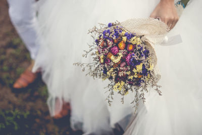 Midsection of woman holding bouquet