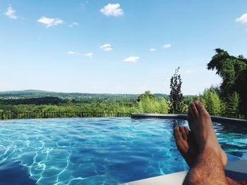 Low section of person relaxing in swimming pool