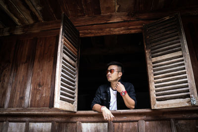 Portrait of young man sitting on wood