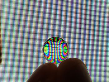 Close-up of hand holding multi colored umbrella