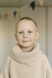 Smiling cute boy wearing turtleneck sweater at home