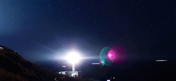 Low angle view of illuminated lights against sky at night