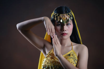 Portrait of beautiful woman standing against black background