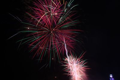 Low angle view of firework display at night