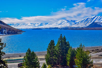 Scenic view of sea and mountains against blue sky