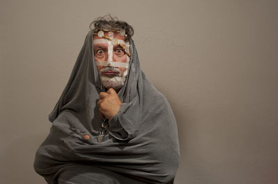 Portrait of man wearing mask against wall