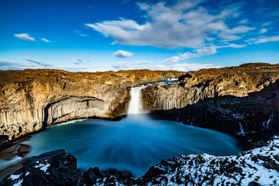 Scenic view of waterfall against sky