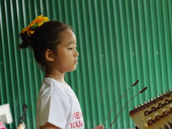 Side view of girl playing musical instrument