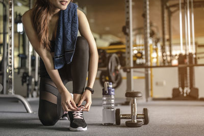 Low section of woman tying shoelace