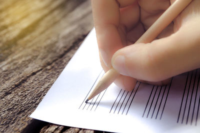 Cropped image of child writing on paper