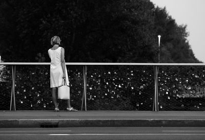 Side view of woman standing on bridge