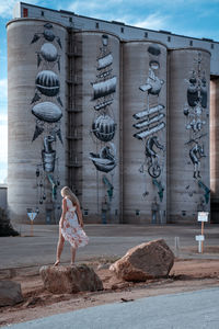 Woman with sculpture in front of building