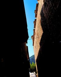 Low angle view of silhouette buildings against clear sky