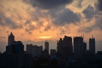 High section of silhouette buildings against sky at dusk