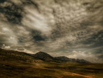 Scenic view of mountains against cloudy sky