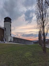 Built structure on field against sky at sunset