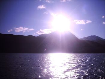 Scenic view of sea against bright sun