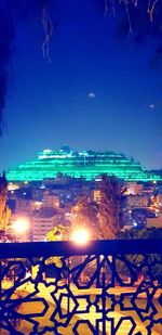 Illuminated city against sky at night