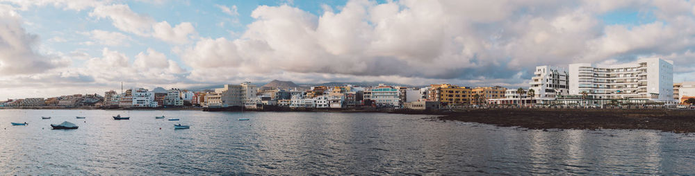 Panoramic view of sea and buildings against sky