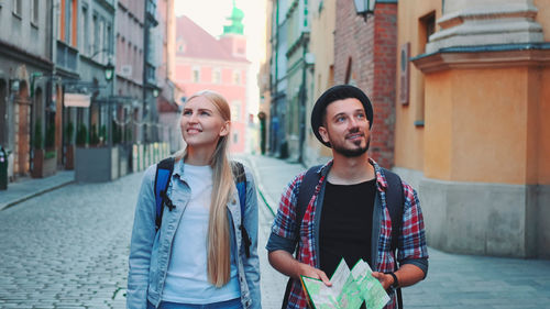 Portrait of smiling friends standing in city