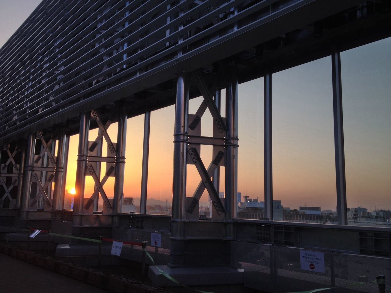 architecture, built structure, sunset, building exterior, orange color, sky, city, low angle view, building, no people, metal, outdoors, illuminated, sunlight, bridge - man made structure, industry, reflection, transportation, dusk, clear sky