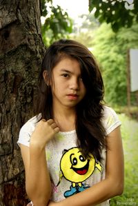 Portrait of girl with tree trunk