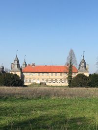 Building on field against clear sky