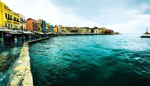 Scenic view of sea by city against sky