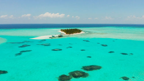 Tropical island in the ocean with palm trees on white sand beach. onok island, balabac, philippines.