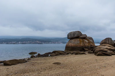 Rocks on sea shore against sky