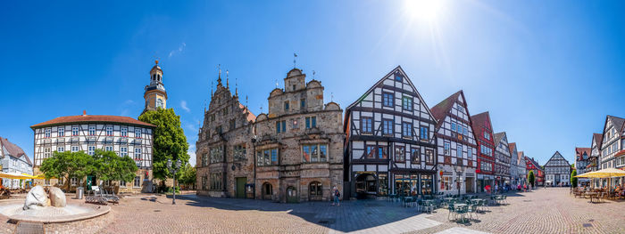 Panoramic view of buildings in city against blue sky
