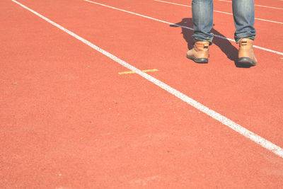 Low section of man standing on sports track