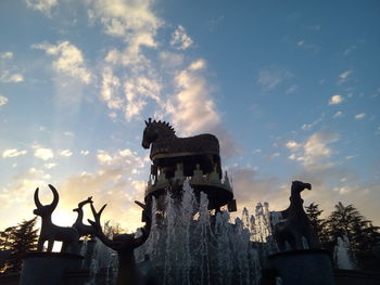 Low angle view of old statue against sky during sunset