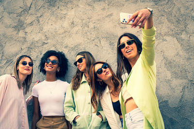 Friends standing against wall